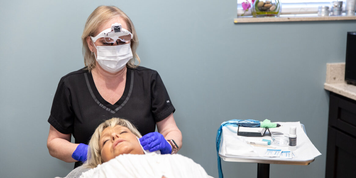 female doctor touching patients head that is laying down