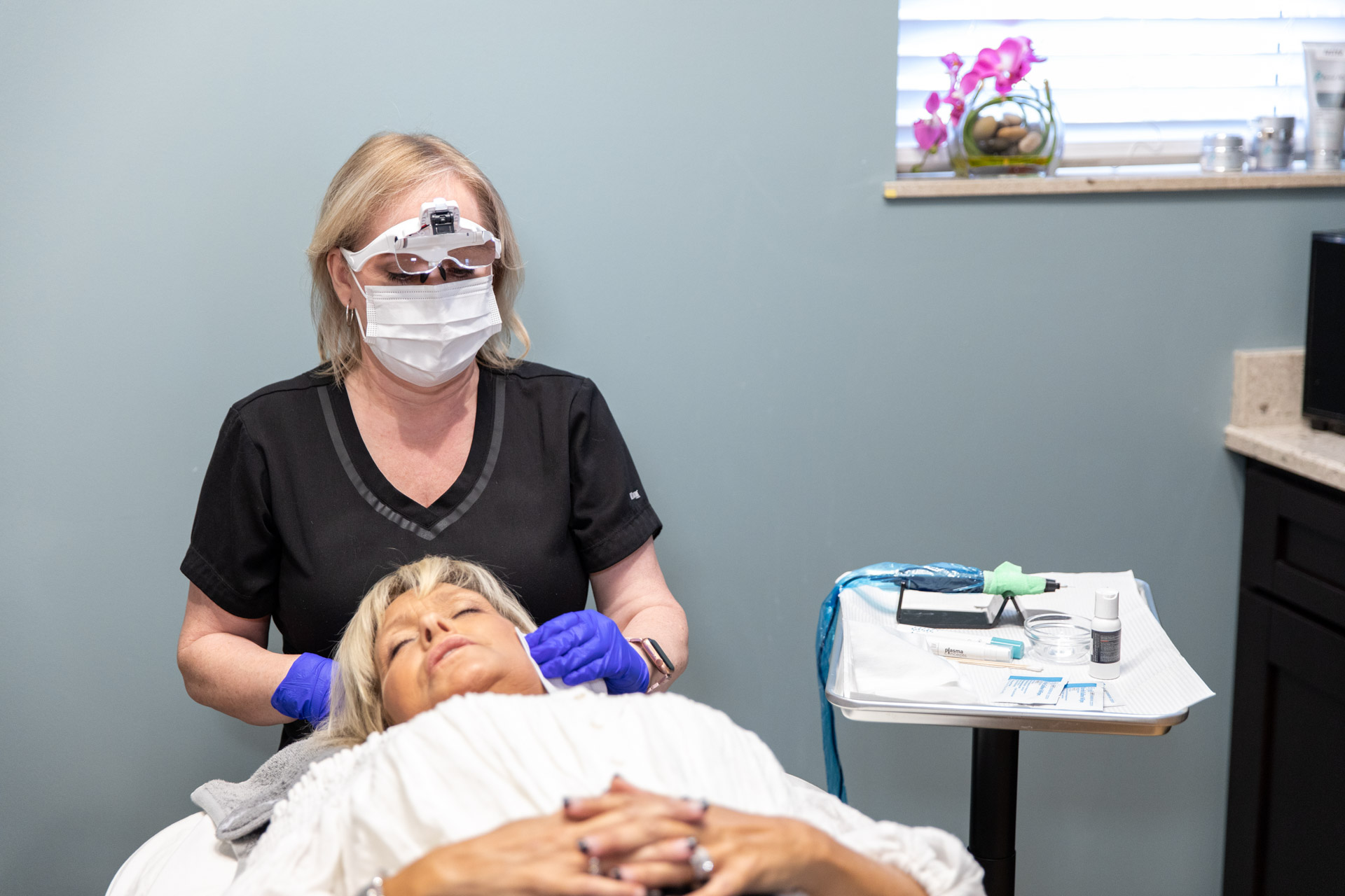 female doctor touching patients head that is laying down