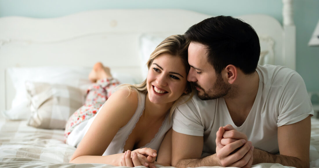 Couple in love wearing pajamas lying in bed