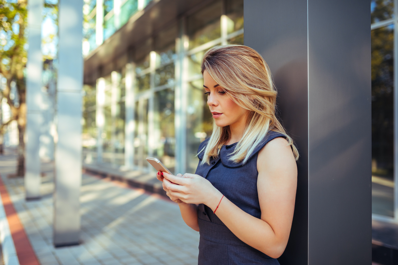 Beautiful woman texting on the mobile phone.