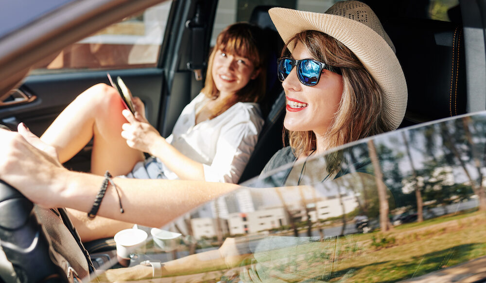 Pretty smiling woman driving car