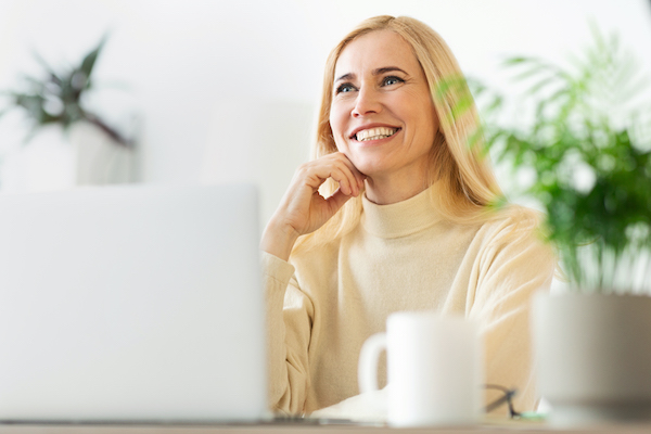 Freelance job concept. Middle-aged woman working on laptop