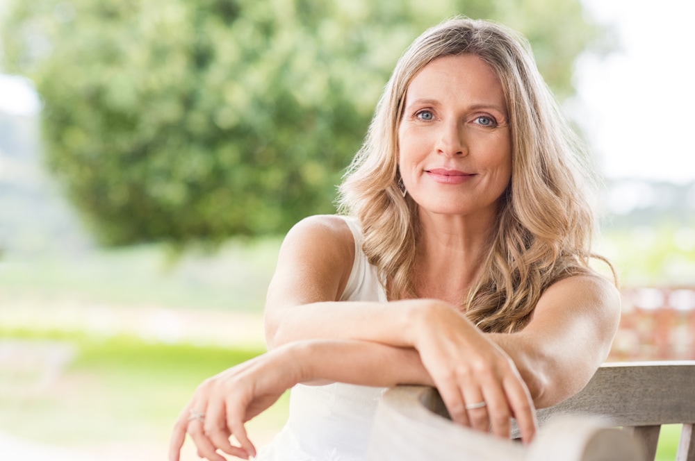 older white women staring at camera with trees in the background