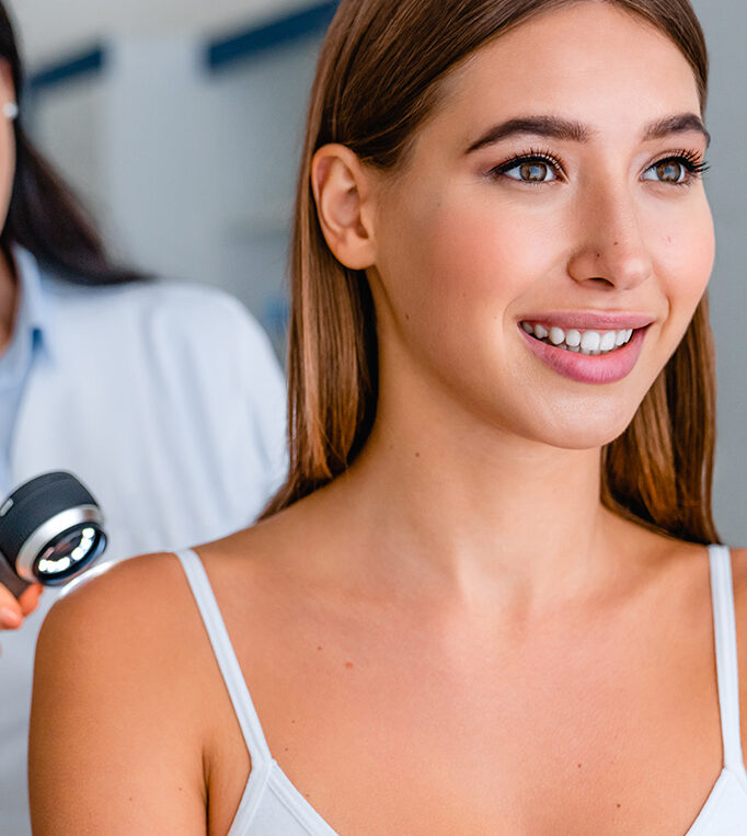 Woman with radiant, glowing skin after a DiamondGlow facial treatment, smiling during a skincare consultation at a medical spa.