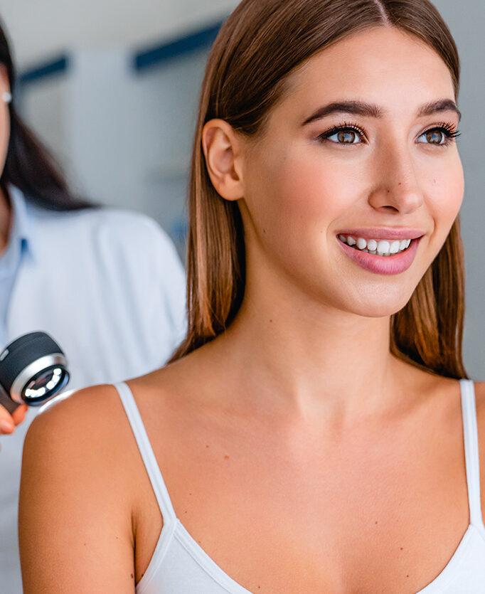 Woman with radiant, glowing skin after a DiamondGlow facial treatment, smiling during a skincare consultation at a medical spa.