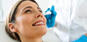 Patient receiving a facial injection treatment from a medical professional wearing blue gloves.