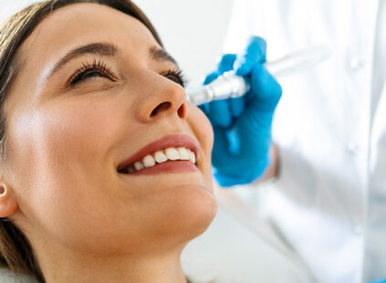 Patient receiving a facial injection treatment from a medical professional wearing blue gloves.