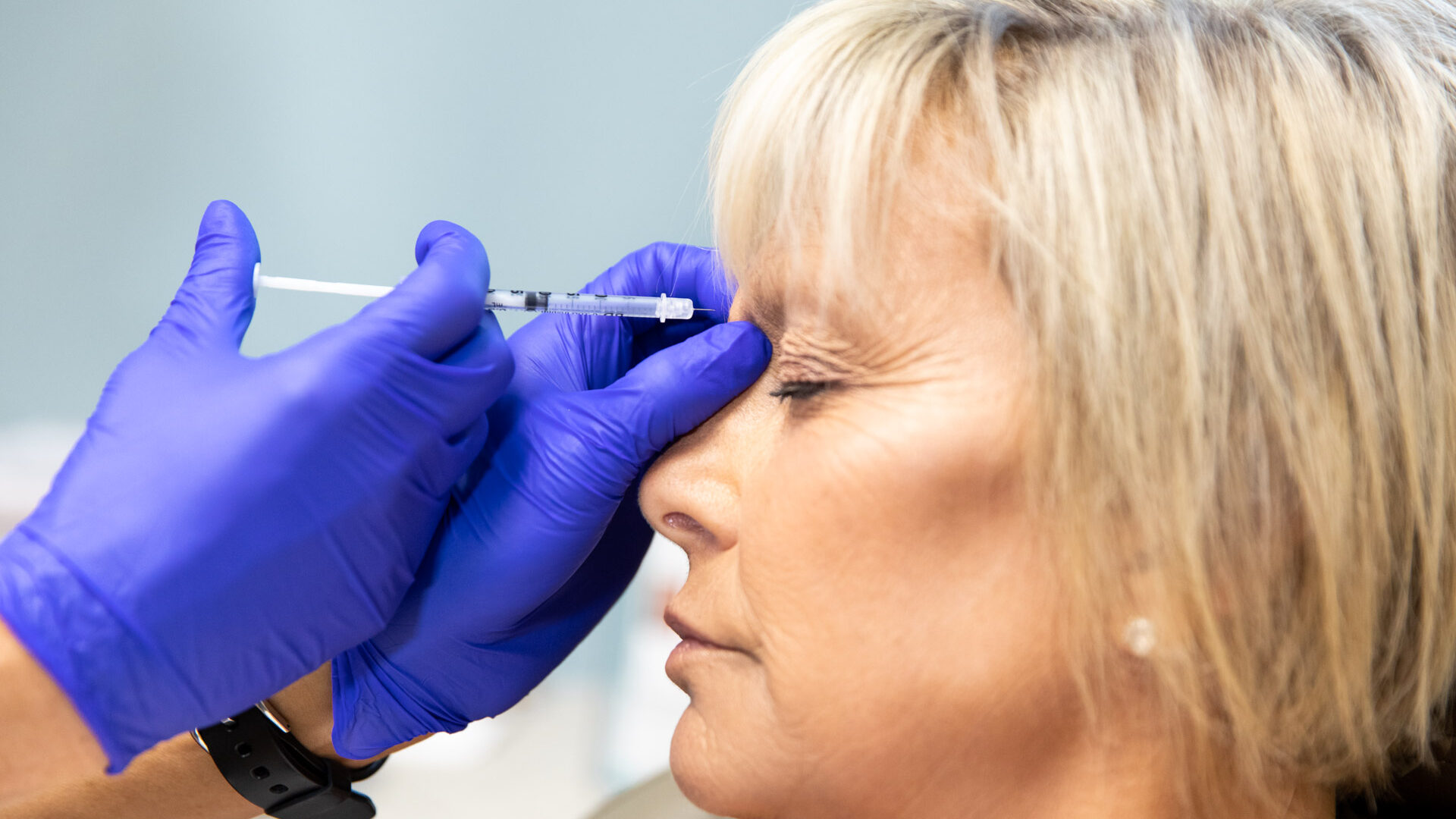 Woman receiving Botox injection near the eye area to reduce wrinkles and fine lines.